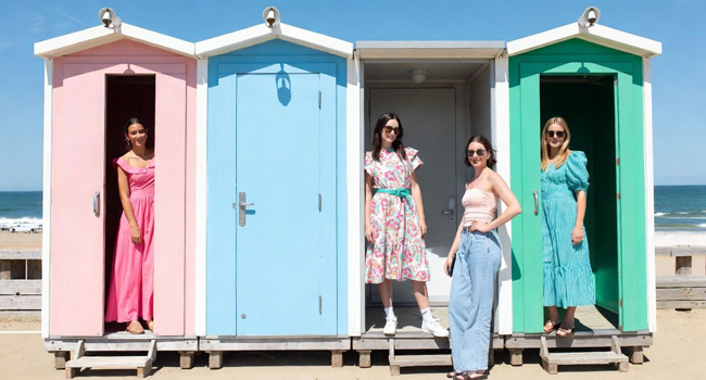Séjours linguistiques en Angleterre Bournemouth avec LISA! – cabanes de plage, mer et temps libre détente Adultes devant des cabanes de plage colorées à Bournemouth Angleterre lors d’un séjour linguistique LISA! profitant de la mer