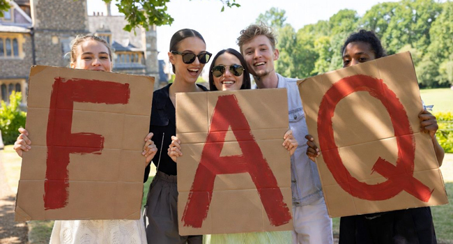 Adultes participants à un séjour linguistique LISA! à Cambridge City Angleterre tiennent des lettres FAQ dans un parc