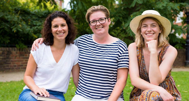 Participantes adultes d’un séjour linguistique LISA! à Cambridge City Angleterre assises dans un parc profitent du temps ensemble