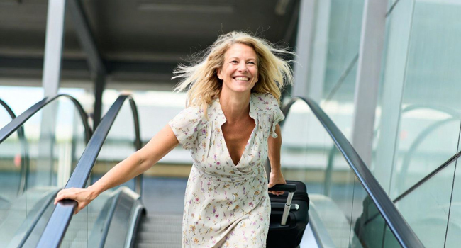 Congé de formation Malte Sliema avec LISA! – apprendre l’anglais et voyager sereinement Adulte avec valise à l’aéroport lors d’un congé de formation LISA! enthousiaste à l’idée de partir à Malte pour apprendre l’anglais