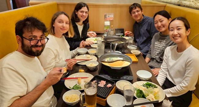 Congé de formation Osaka Japon avec LISA! – apprendre le japonais, gastronomie et expériences partagées Adultes mangent ensemble dans un restaurant à Osaka lors d’un congé de formation LISA! découvrent la cuisine japonaise et l’ambiance internationale