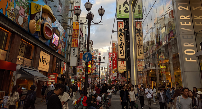 Congé de formation Osaka Japon avec LISA! – apprendre le japonais, ville et expériences authentiques Rue animée à Osaka lors d’un congé de formation LISA! avec culture japonaise, néons et vie urbaine