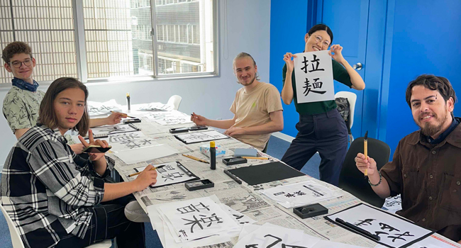 Adultes apprennent les caractères japonais en cours à Tokyo lors d’un séjour linguistique LISA! pratiquent la calligraphie