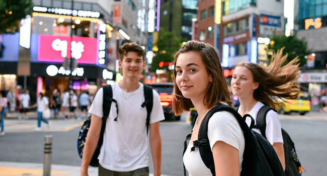 Séjours linguistiques Séoul Hongdae avec LISA! – ville, rencontres et expériences inoubliables Jeunes adultes traversent la rue à Séoul Hongdae lors d’un séjour linguistique LISA! découvrent la vie urbaine animée
