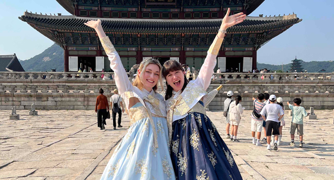 Séjours linguistiques Séoul Hongdae avec LISA! – culture, tradition et expériences inoubliables en Corée Adultes en vêtements traditionnels coréens devant un temple à Séoul lors d’un séjour linguistique LISA! découvrent la culture
