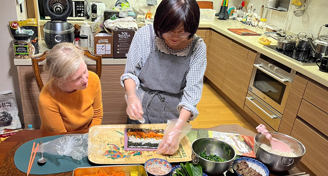 Séjours linguistiques Séoul Hongdae avec LISA! – famille d’accueil, cuisine et expériences culturelles en Corée Adultes cuisinent avec une famille d’accueil à Séoul lors d’un séjour linguistique LISA! découvrent la cuisine coréenne