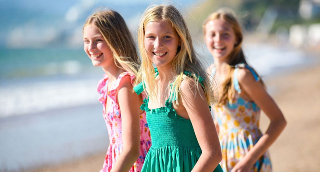 Séjours linguistiques en Angleterre Bournemouth avec LISA! – plage, été et expériences inoubliables Trois étudiantes sur la plage à Bournemouth Angleterre lors d’un séjour linguistique LISA! portent des robes d’été et profitent de la mer