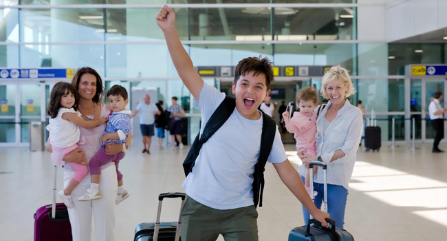 Arrivée pour un séjour linguistique pour étudiants en Angleterre Brighton avec LISA! – étudiant heureux à l’aéroport Étudiant arrivant à l’aéroport avec le bras levé enthousiaste pour un séjour linguistique LISA! pour étudiants en Angleterre Brighton