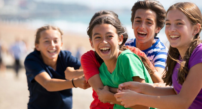 Groupe d’étudiants à Eastbourne Angleterre lors d’un séjour linguistique LISA! jouent ensemble sur la plage et se sentent en sécurité