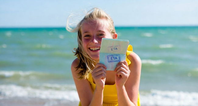 Séjours linguistiques à Exmouth avec LISA! – entrée, ETA et informations importantes pour étudiants Étudiante sur la plage à Exmouth lors d’un séjour linguistique LISA! montre un document ETA d’entrée pour l’Angleterre