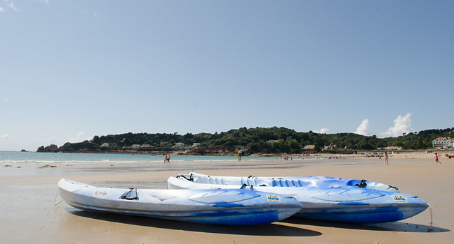  Plage à Jersey avec kayaks au bord de la mer lors d’un séjour linguistique LISA! pour étudiants avec programme d’activités
