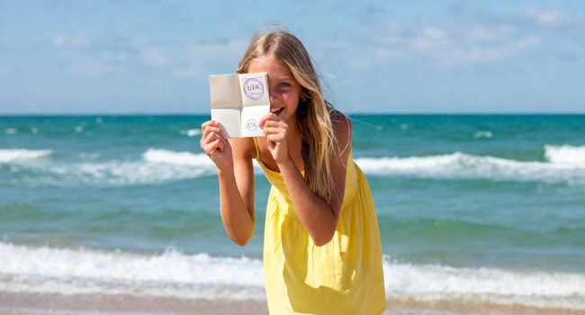 Séjours linguistiques à Portsmouth avec LISA! – entrée, visa et informations importantes pour étudiants Étudiante sur la plage à Portsmouth lors d’un séjour linguistique LISA! montre un document d’entrée pour l’Angleterre