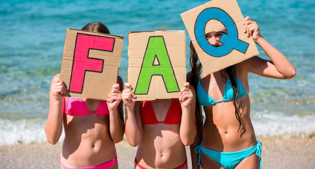 FAQ séjours linguistiques LISA! Portsmouth – réponses pour étudiants Étudiantes sur la plage à Portsmouth tiennent des lettres FAQ lors d’un séjour linguistique LISA! avec la mer en arrière-plan