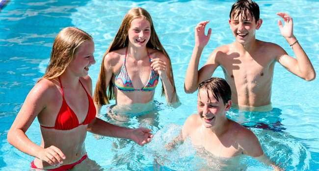 Quatre étudiants s’amusent dans la piscine lors d’un séjour linguistique LISA! pour étudiants à Malte