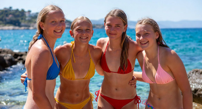 Quatre jeunes filles au bord de la mer en bikinis colorés lors d’un séjour linguistique à Malte San Gwann