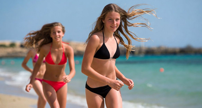Deux jeunes filles courant sur la plage à Malte lors d’un séjour linguistique LISA! pour étudiants