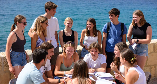 De nombreux étudiants au bord de la mer pendant le programme d’activités symbolisent le programme d’activités LISA! à Sliema, Malte.