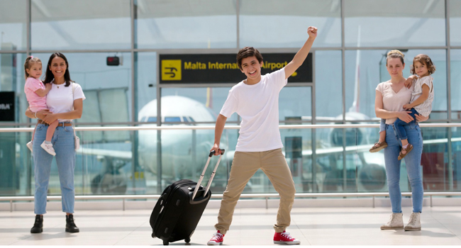 Des étudiants d’un séjour linguistique d’anglais à Malte lors de l’arrivée à l’aéroport avec valise et scène d’accueil
