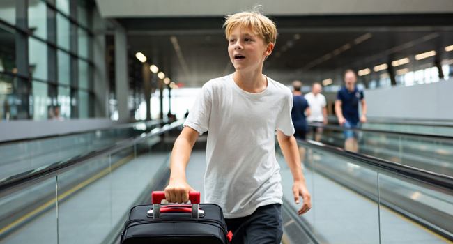Arrivée à un séjour linguistique LISA! pour étudiants à Málaga, Espagne – un garçon sur un tapis roulant à l’aéroport. Un garçon arrivant sur un tapis roulant à l’aéroport pour un séjour linguistique pour étudiants à Málaga symbolise l’arrivée à un séjour linguistique LISA! pour étudiants à Málaga, Espagne.