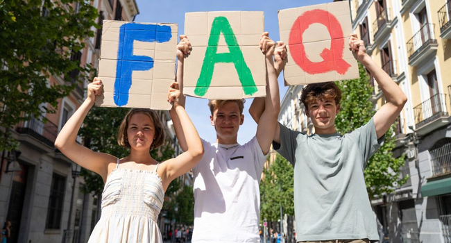 Participants tenant des panneaux FAQ pendant un cours d’espagnol pour jeunes adultes à Madrid