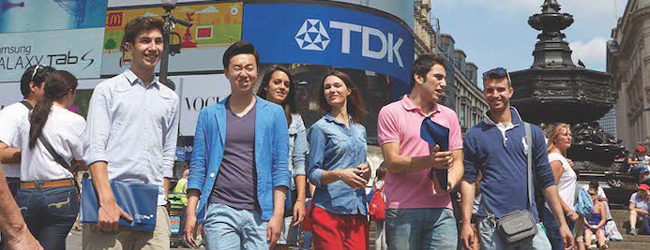 Eine Gruppe von Menschen sieht sich am Travalgar Square in London um Gruppe von Teilnehmern an einer Sprachreise in London am Travalgar Square