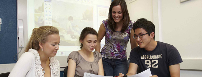 Gemeinsames Lernen bei einem Sprachkurs Englisch in London Eine Lehrerin erklärt drei Schülern im Englisch-Unterricht etwas bei einem Sprachkurs in London