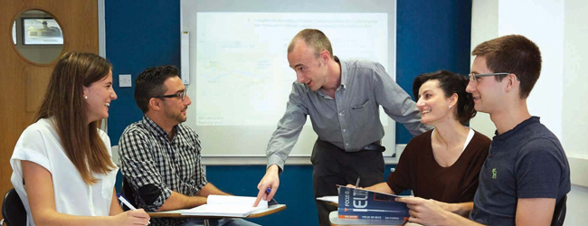 Englisch-Sprachunterricht mit einem Lehrer bei einer LISA! Sprachreise in London Ein Lehrer erklärt vier Studenten im Sprachunterricht etwas bei einer LISA! Sprachreise in London