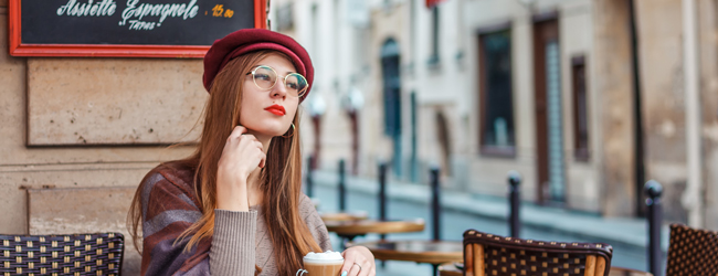 Junge Dame denkt nach und sitzt in einem Cafe bei einer LISA! Sprachreise in Paris