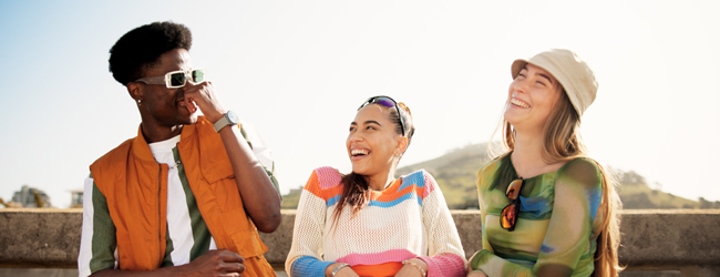 Lachen und Lernen auf La Réunion – Sprachreisen mit LISA! Zwei junge Frauen und ein Mann genießen ihre Zeit und lachen gemeinsam während ihrer Sprachreise auf La Réunion mit LISA!