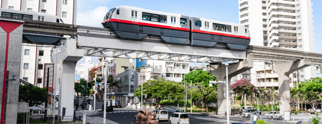 Verkehrsmittel in Naha bei einer Sprachreise in Naha in Okinawa Hochbahn in Naha in Okinawa, darunter Strassen und Autos zwischen Hochhäusern