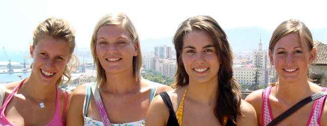 Schöne Zeit im Sommer in Malaga bei einem Spanisch-Sprachkurs Vier Mädchen lächeln in die Kamera im Hintergrund der Hafen von Malaga