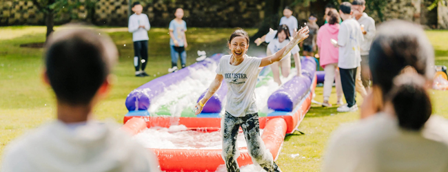 Kinder haben Spass bei einer Wasser-Seifen-Rutsche im Garten der LISA! Sprachschule in London Highgate