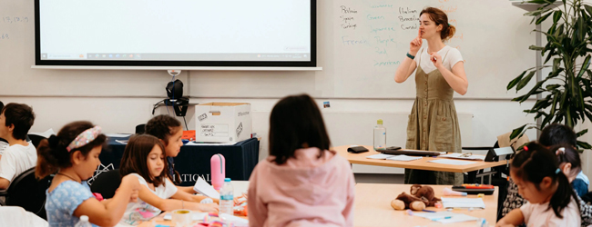 Eine Lehrerin erklärt vor einer Klasse mit Kindern bei einer Familiensprachreise in London