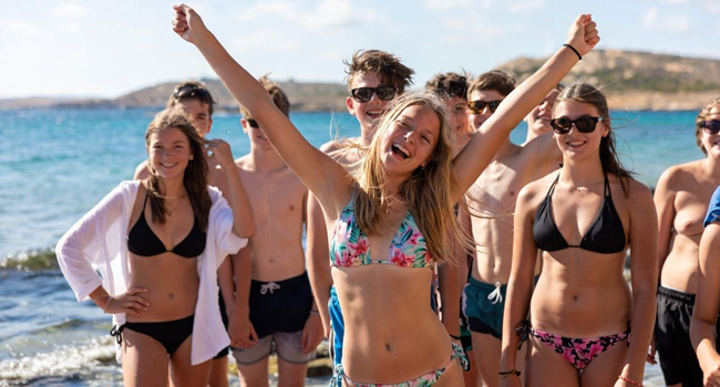 10 Teenager mit Mädchen die arme hochreckt haben eine Sprachreise Malta St. Julians gebucht