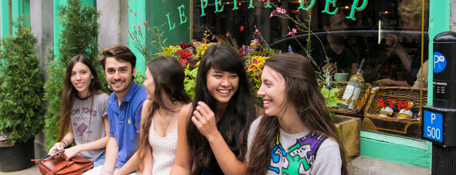 Schülerinnen und ein Betreuer sitzen vor einem Geschäft bei einer LISA! Sprachreise für Schüler in Montreal