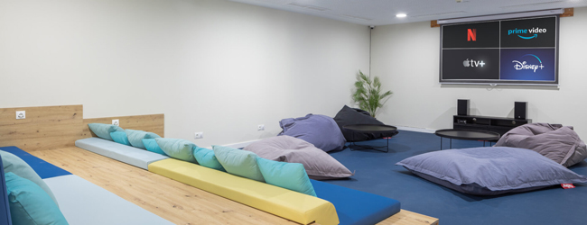 Lounge und Kino in der LISA! Sprachschule in Malaga Campus Blick in den Kinoraum und Lounge mit bequemen Kissen und grossem TV in der Sprachschule in Malaga